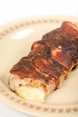 Melted yellow cheese in rolled steak with bacon