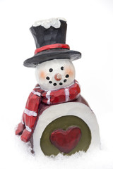 Carved vintage snowman ornament with heart on belly sitting in t