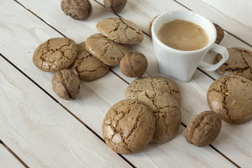 Cup of coffee, macaroons cookies  and walnut on the white wooden background
