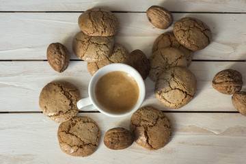 Cup of coffee, macaroons cookies  and walnut on the white wooden background