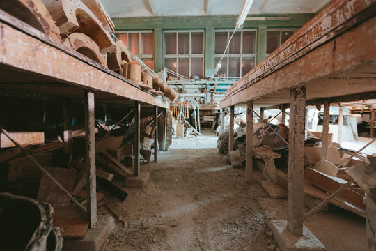 Factory For Production Of Plaster Molds. Cluttered Dusty Old Warehouse At Night