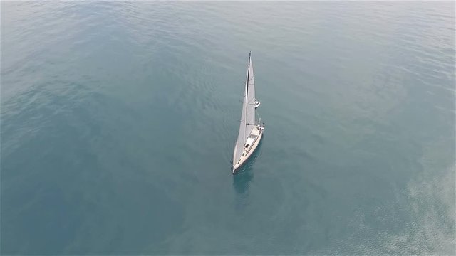 Aerial video of a sailing boat in the blue sea