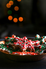 Xmas composition. Gingerbread cookies in the shape of snowflakes in a copper bowl on a dark bokeh background. 