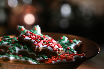 Xmas composition. Gingerbread cookies in the shape of snowflakes in a copper bowl on a dark bokeh background. 