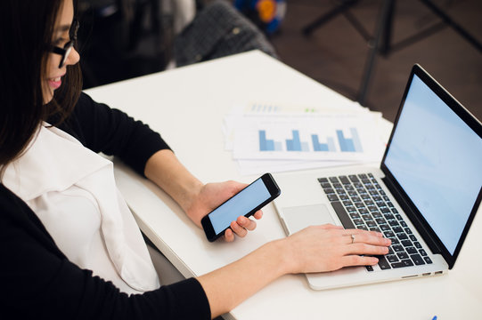 Close Up of woman hands using mobile phone and laptop computer with blank copy space screen for your advertising text message or content business.