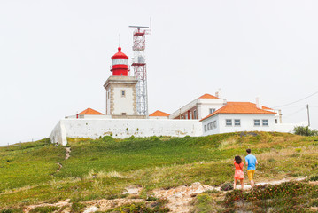 Fototapeta na wymiar Lighthouse with tourist couple background.