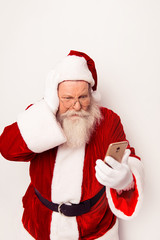 Confused Santa Claus wearing red costume reading messege on phon