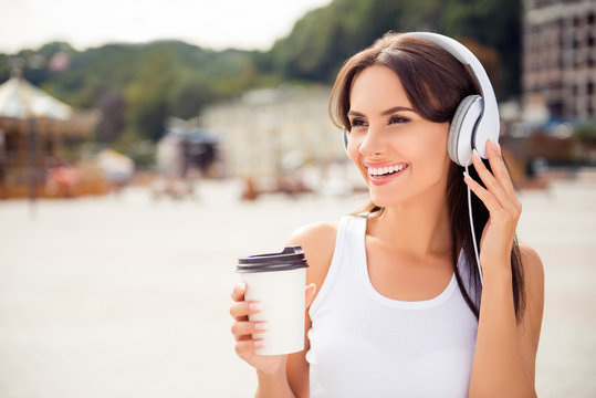 Portrait of happy relaxed woman listening music in headphones an