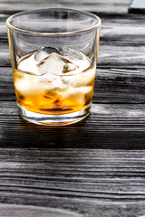glass of whiskey on dark wooden background