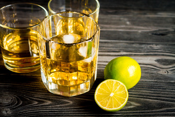 glass of whiskey on dark wooden background