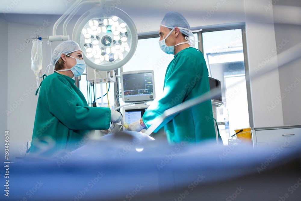Poster surgeons interacting while operating patient