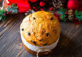 Panettone with fruit, and Christmas decoration, on a wooden back
