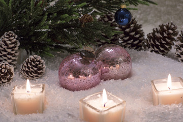 Christmas still life is with snow. Pink glass ball is near the Christmas tree. 