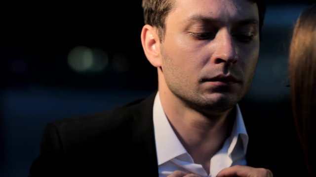 Girl slowly unbuttoning a white shirt of an upset man