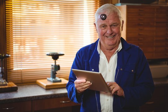 Horologist using digital tablet in workshop - Powered by Adobe