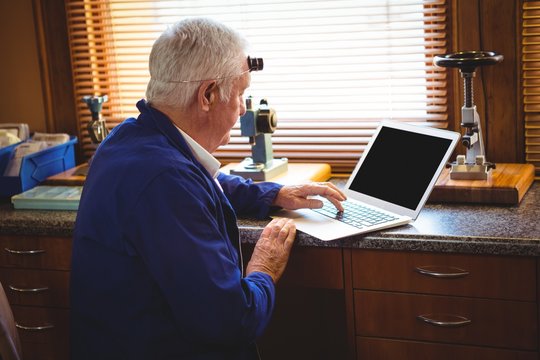 Horologist working on laptop - Powered by Adobe