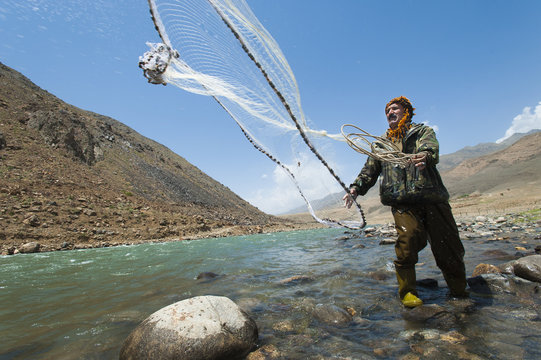 A man from the Panjshir Valley fishes with a throw-net, Afghanistan