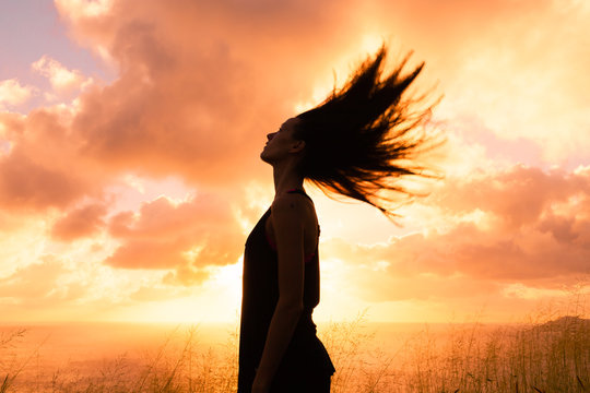 Feeling free. Happy woman outdoors with her hair blowing in the wind.