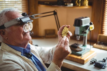 Horologist examining a clock part