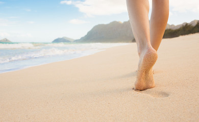 Woman walking on a beautiful white sand beach in  Hawaii. 