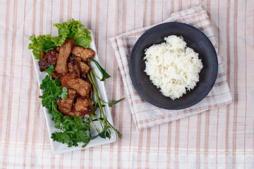 Grilled pork with mixed herb served sticky rice .