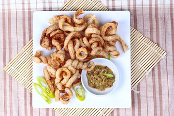 Crispy pork rind  served with green chili dip .