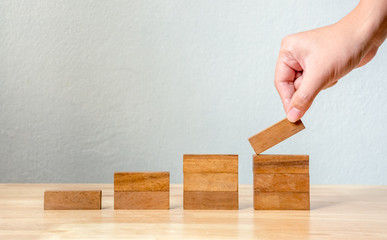 Hand arranging wood block stacking as step stair. Business concept for growth success process