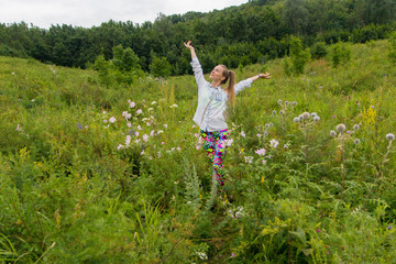 Young girl enjoying nature among the wildflowers in a forest