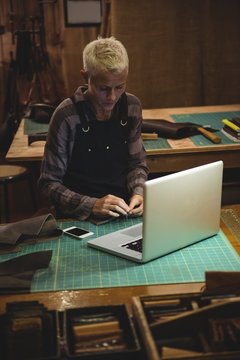 Woman working with laptop and mobile phone on table
