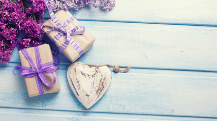 Two festive gift boxes with presents,  decorative heart andlilac