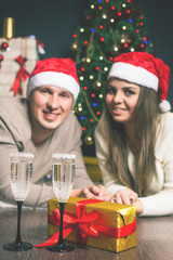 Obraz na płótnie Canvas Couple young near decorated Christmas tree celebrating New Year