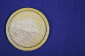 Empty Clay saucer plate isolated on blue fabric texture