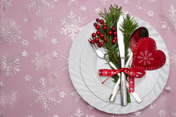 Christmas table place setting with pine branches,ribbon and bow.