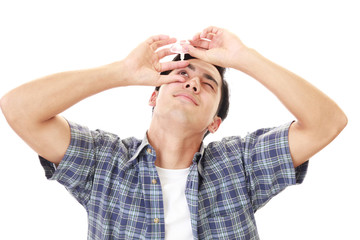 目薬で治療する男性

