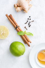 herbal with fresh mint, honey, lemon, ginger cinnamon on carpet background. Top view, copy space..