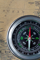 Fototapeta na wymiar the Black compass on old vintage map, ocean, macro background