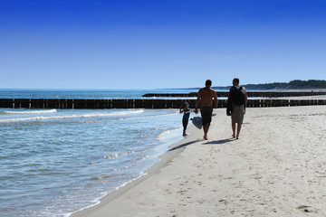 Men with a little boy are on the seashore