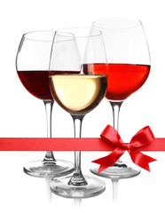 Glasses of different wine with festive ribbon bow on white background. Holiday celebration concept.