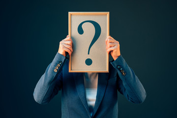Business woman with question mark looking for answers