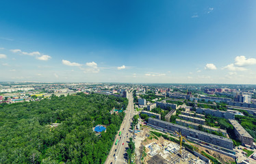 Aerial city view with crossroads and roads, houses, buildings, parks and parking lots, bridges. Urban landscape. Copter shot. Panoramic image.