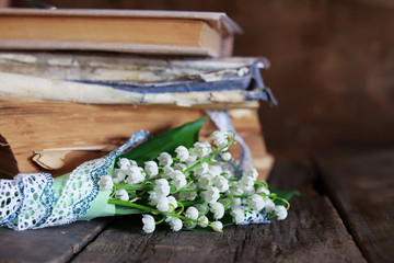 bouquet of fresh lilies of the valley and retro book