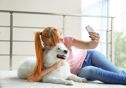 Girl taking selfie with Samoyed dog