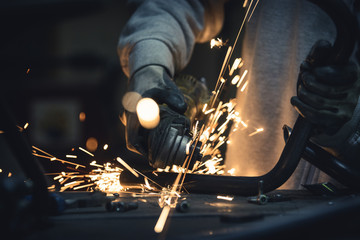 Grinding metal. Steel pipe cutting with flash of sparks close up