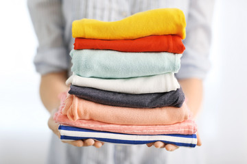 Woman holding stack of clothes, closeup