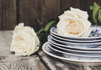 Clean plates with white roses on a wooden table