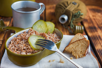 Military food with porridge and tea on old wooden boards close-up