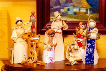 folk style traditional handmade figures made from natural materials doing chores and crafts.