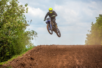 Fototapeta na wymiar Sprung eines Motocross Fahrers über einen Hügel