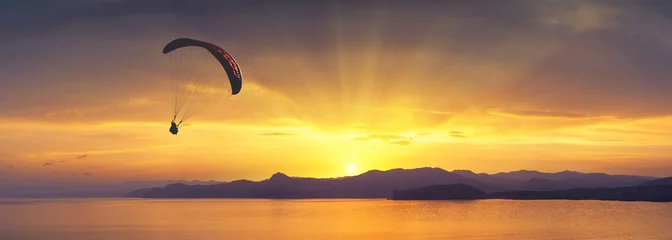 Cercles muraux Sports aériens Au-dessus de la mer contre le coucher du soleil coloré lumineux