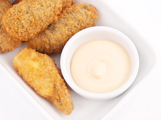 Croquetas casera junto a un cuenco con salsa. Vista superior